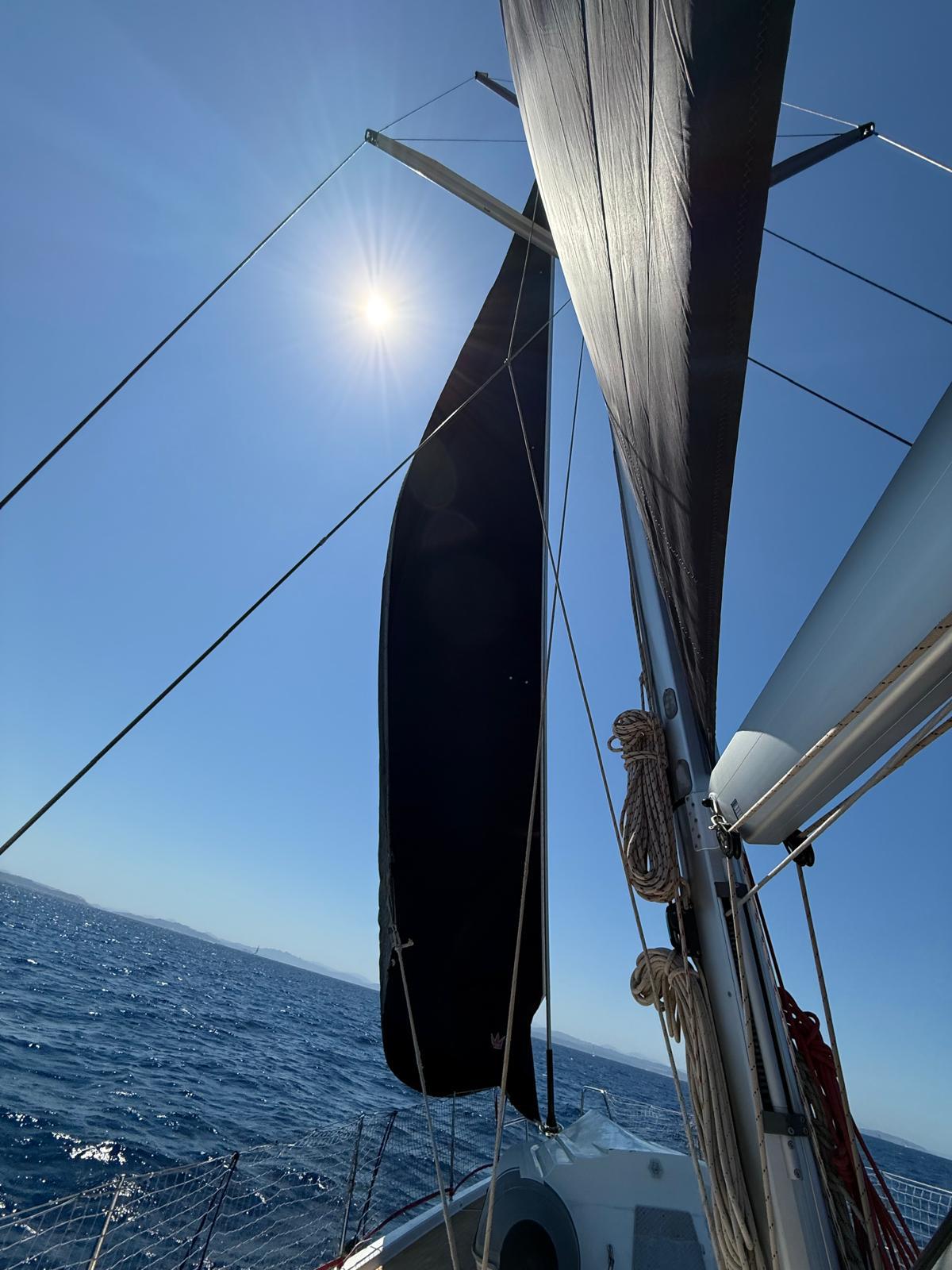 Segel eines Segelboots vor strahlend blauem Himmel und Sonne